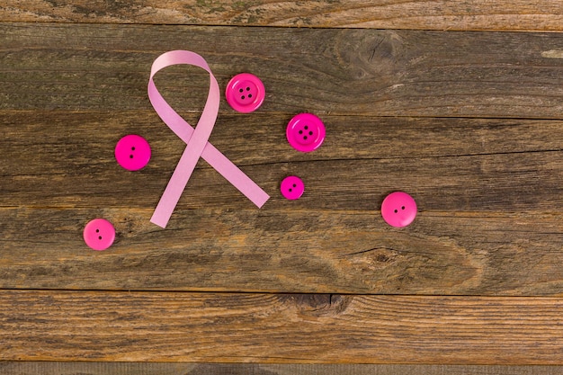 木の板にピンクのリボンで女性の健康のシンボル。
