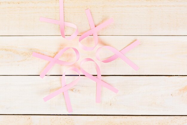 Womens health symbol in pink ribbon on wooden board.