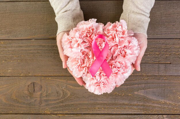 Womens health symbol in pink ribbon on wooden board.