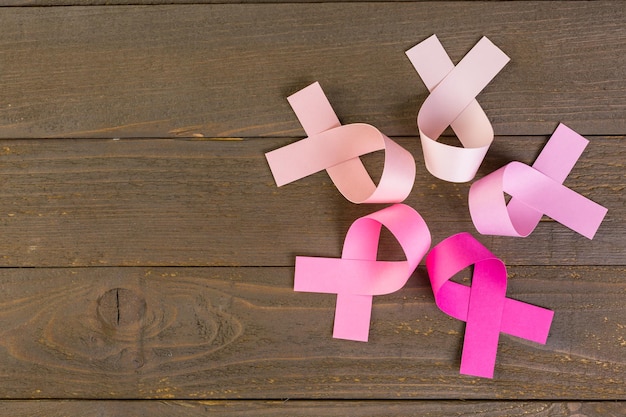 Womens health symbol in pink ribbon on wooden board.