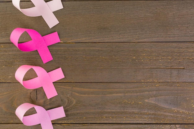 Womens health symbol in pink ribbon on wooden board.