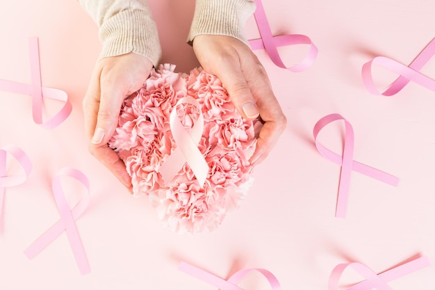 Womens health symbol in pink ribbon on wooden board.