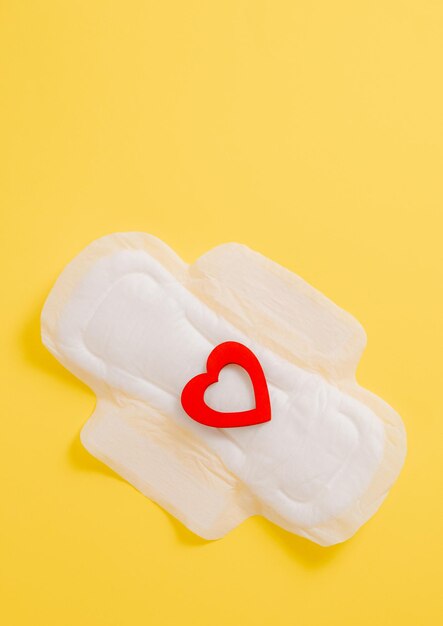 Womens sanitary pad with a red heart on a yellow background