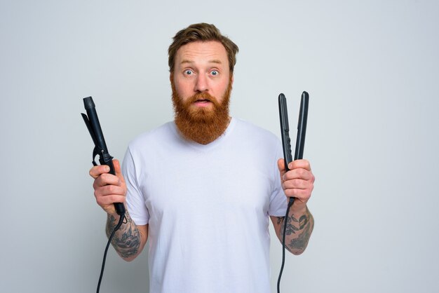 Wondered man with hair straightener is ready to work