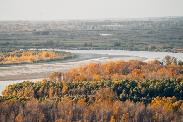 Прекрасный осенний пейзаж с рощей и рекой.