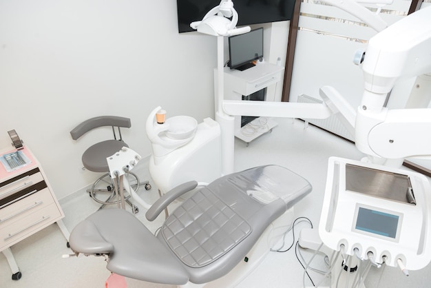 Wonderful clean dentistry office with grey seat and white equipment in a clinic