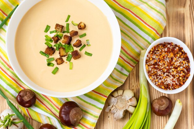 Wonderful cream soup of chestnuts on a wooden table.