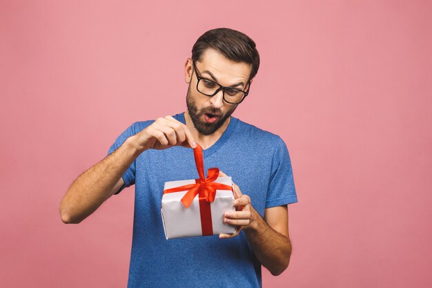 Wonderful gift! Adorable photo of attractive man with beautiful smile holding his birthday present box