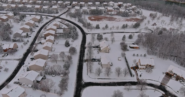 素晴らしい冬の風景の屋根には、住宅の小さなtで空中写真に覆われた雪の木があります