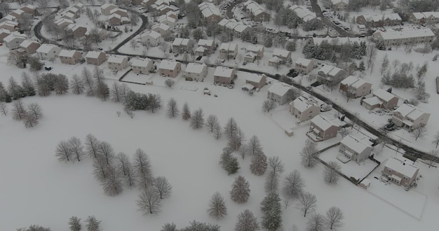 素晴らしい冬の風景の屋根には、住宅の小さなtで空中写真に覆われた雪の木があります