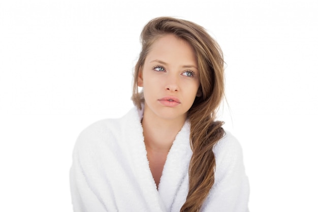 Wondering brunette in bathrobe looking away