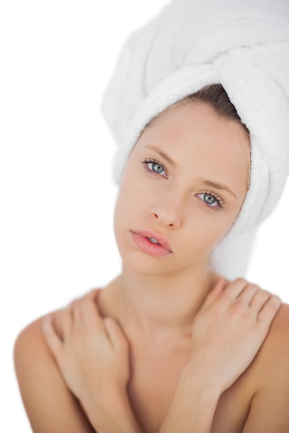 Photo wondering brunette drying her hair looking at camera