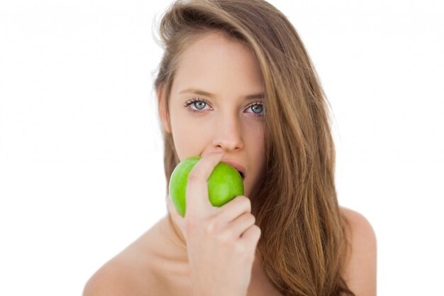 Wondering brunette model eating an apple