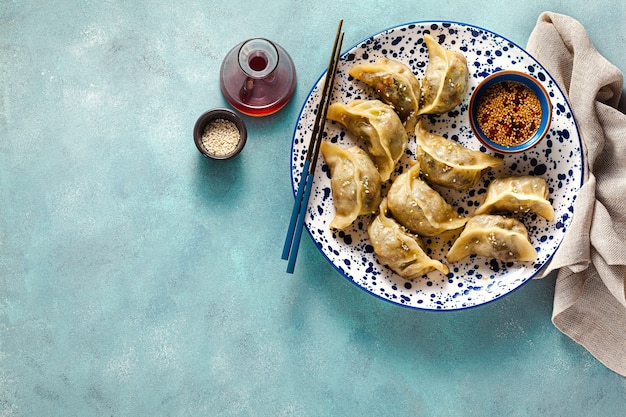 Wonton dumplings met pikante sesamsaus op tafel.