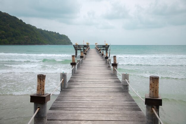 wood bridge on beach. cloudy sky with copy space.