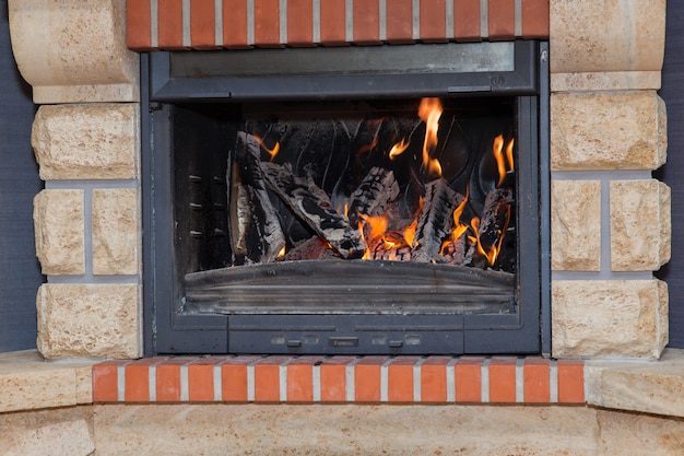 Photo wood burning in the fireplace close-up