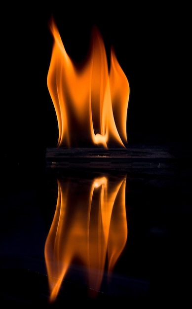 사진 밤에는 물 위에 반사되는 불타는 나무