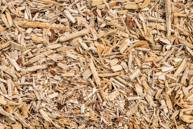 木材チップと削りくずは地面に平らに横たわっています自然な背景と木の質感