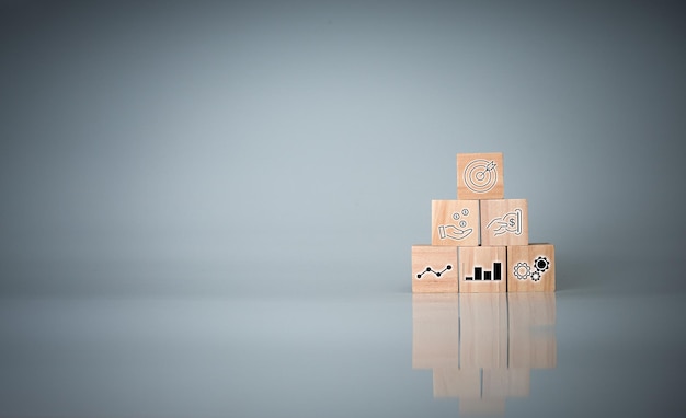 Wood cube block stacking with iconConcept of business strategy and goal action plan