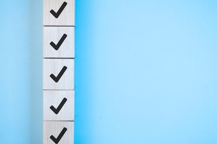 Photo wood cube with check mark on blue background, checklist concept, copy space.