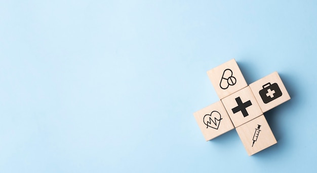 Wood cube with medical symbol on pastel blue