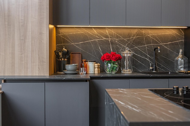 wood decorated dark kitchen area with coocking island in huge modern spacious apartment with high loft style ceilings wooden decoration and grey walls