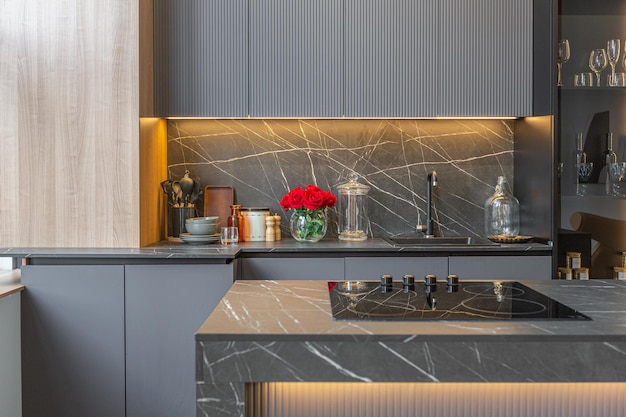 wood decorated dark kitchen area with coocking island in huge modern spacious apartment with high loft style ceilings wooden decoration and grey walls