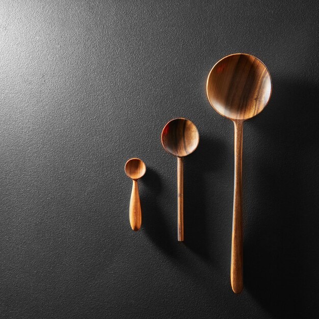 Wood different spoons on black board background.