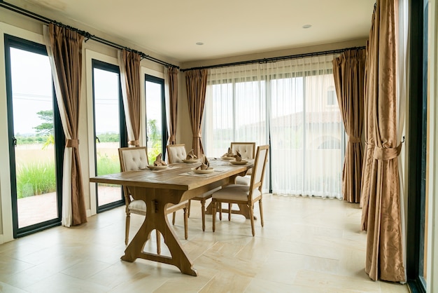 wood dinning table in a room with curtain and window