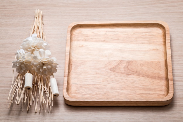 Wood dish with dried flower on the wooden table.