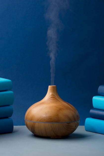 wood fragrance on the table with natural oils essence vapor, with blue and teal colored books