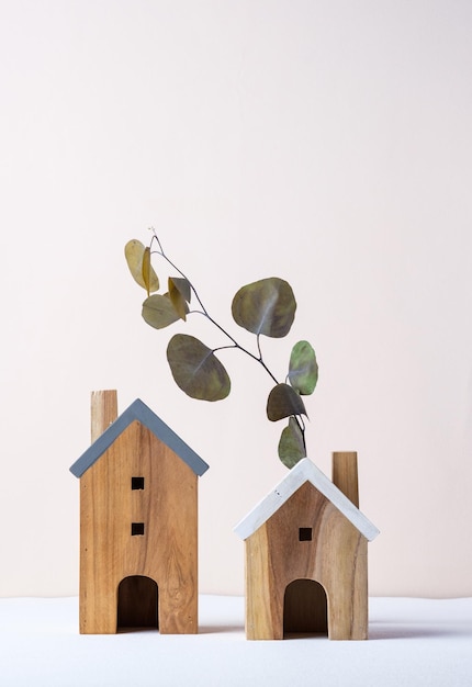 Wood home toy craftmanship on white table and green wall with eucalyptus leaf