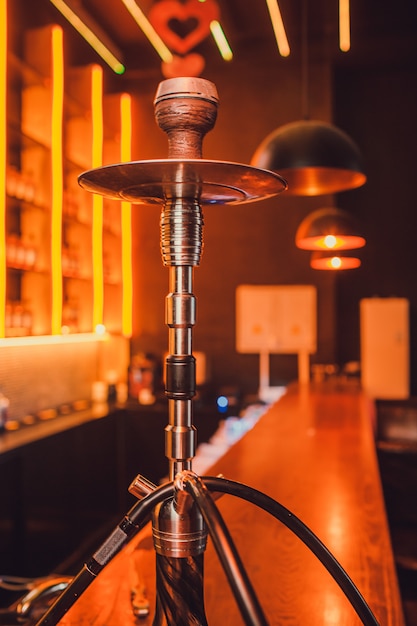 Wood hookah on table in hookah lounge.