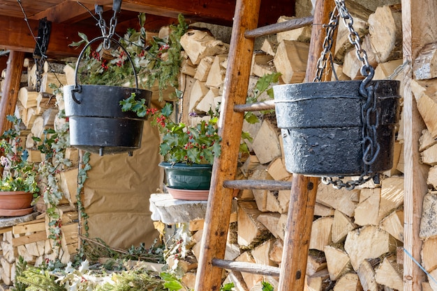 Wood logs rows with black cauldrons and ladder