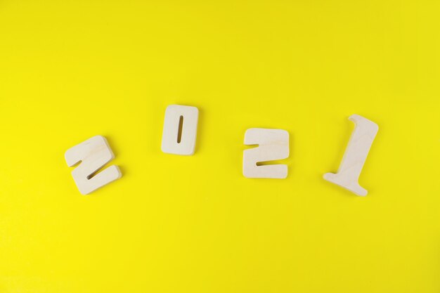 Wood number 2021 for New Year concept on yellow background.