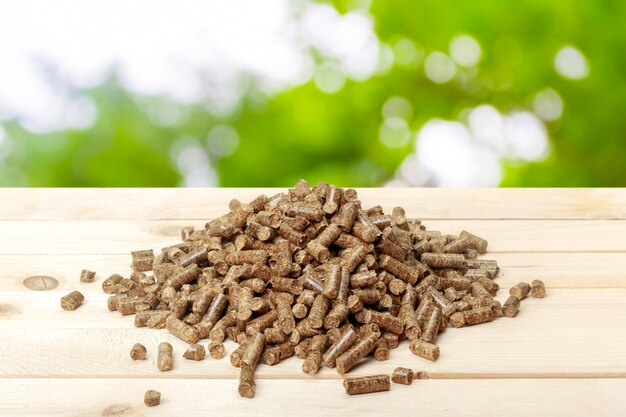 Wood pellets on a green . Biofuels.