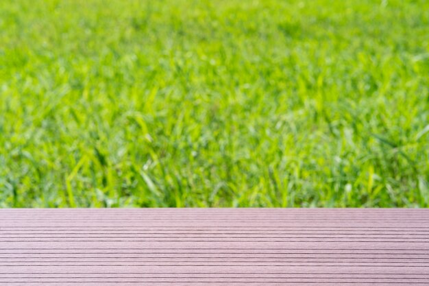 Wood plank on natural green grass field in countryside