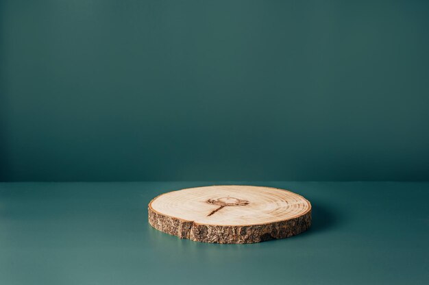 Wood podium saw cut of tree on dark teal background