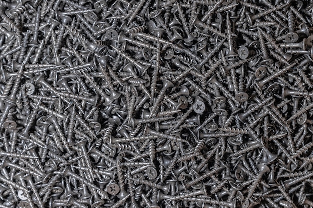 Wood screws. Texture. Background for wallpaper. A lot of black screws. View from above.