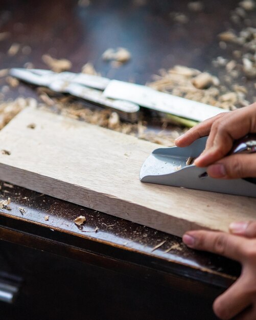 Photo wood shavings carpenter working with a metal spokeshave and a blurry background