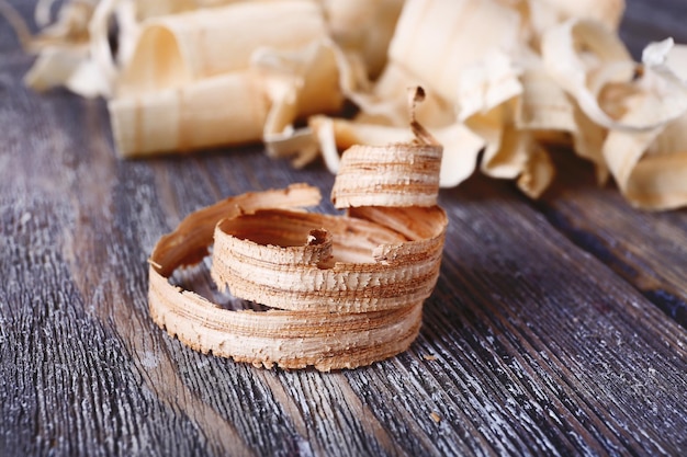 Wood shavings on grey wooden background closeup