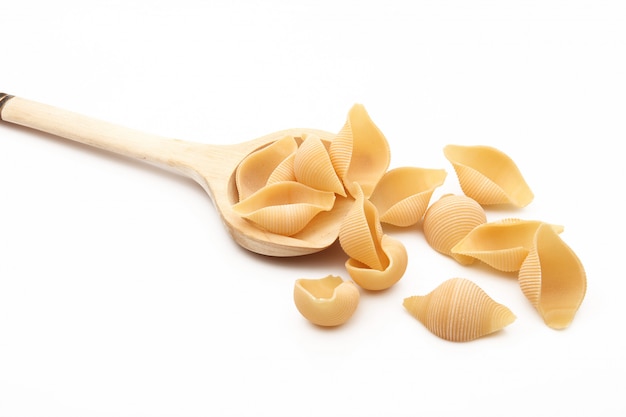 Wood spoon with italian pasta on white