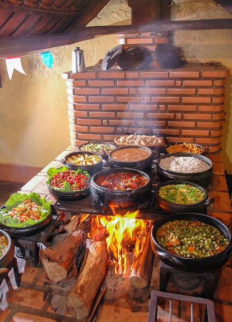 オクラ豆ソーセージ米tropeiroとブラジルの鶏肉の内部にある典型的な田舎の家の薪ストーブ
