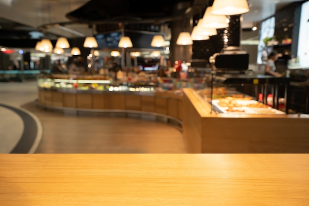 Wood table in blurry background of modern restaurant room or coffee shop for product display mockup