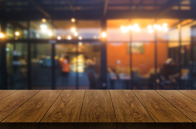 Wood table in blurry background of modern restaurant room or coffee shop for product display mockup