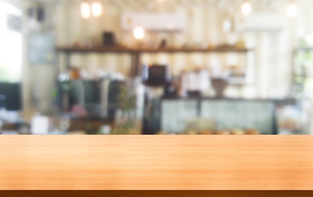 Tavolo in legno sullo sfondo sfocato della moderna sala ristorante o caffetteria per il modello di visualizzazione del prodotto.