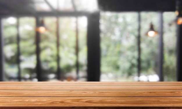 Wood table in blurry background of modern restaurant room or coffee shop for product display mockup.