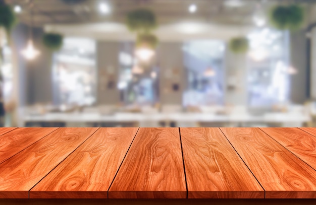 Wood table in blurry background of modern restaurant room or coffee shop for product display mockup.