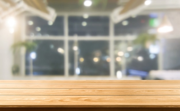 Wood table in blurry background of modern restaurant room or coffee shop for product display mockup.