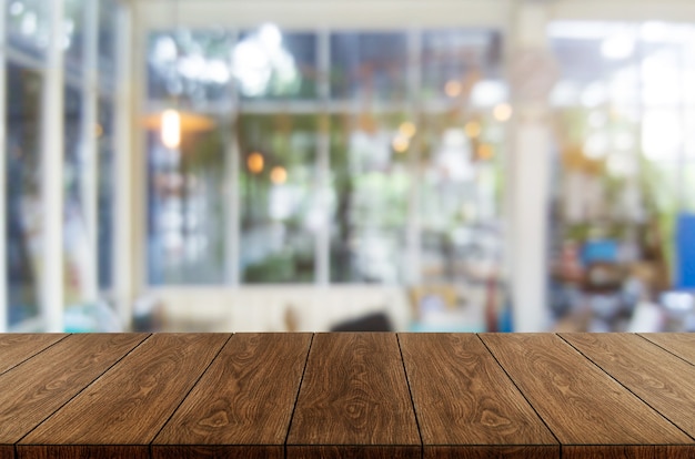 Wood table in blurry background of modern restaurant room or coffee shop for product display